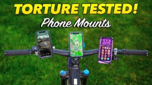 A bicycle handlebar with three phones mounted on it.