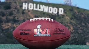 A picture of a football and in the background the iconic HOLLYWOOD sign in the hills. This is for the Superbowl in LA, Feb. 2022/